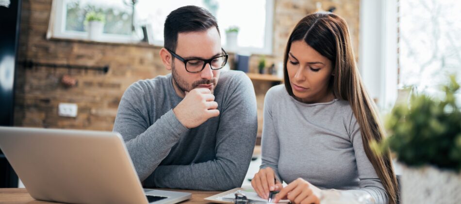 Man and woman looking at laptop on desk