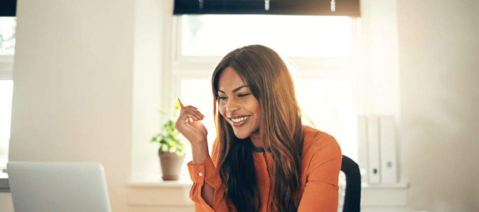 Woman smiling while looking at laptop