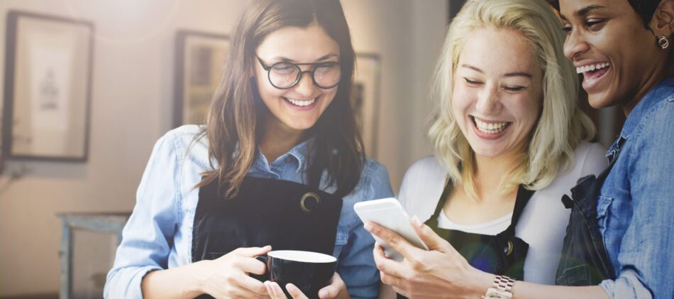 Workers at a coffee shop looking at something and smiling