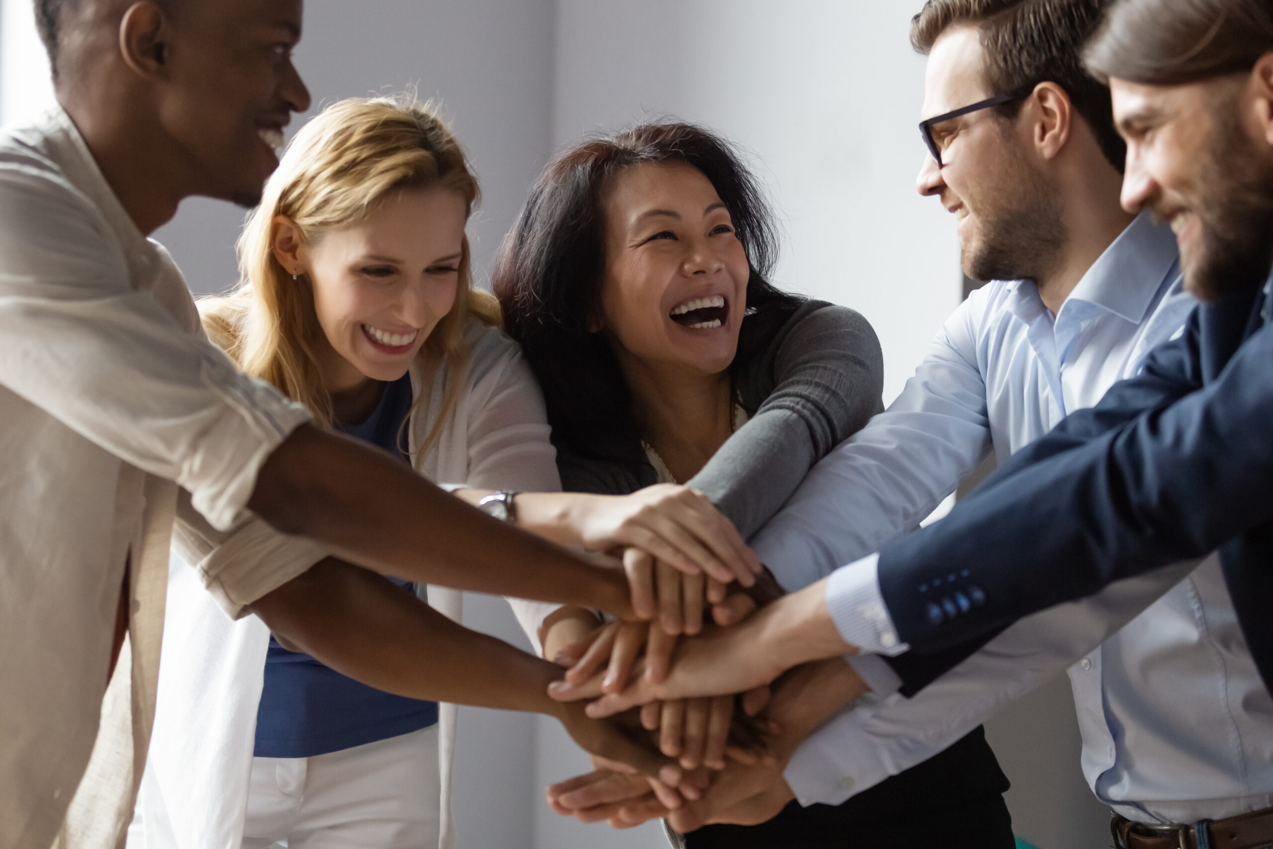 Professional business team in a circle with their hands all in the center
